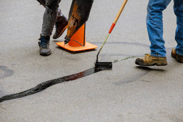 Road surface restoration work in the worker performs on road patcher work on the repair of cracks