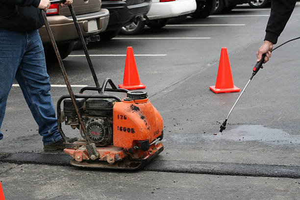 A tamper/vibrating machine compressing a new asphalt patch.